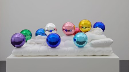 A marble sculpture of a sleeping figure covered with colorful highly polished orbs.