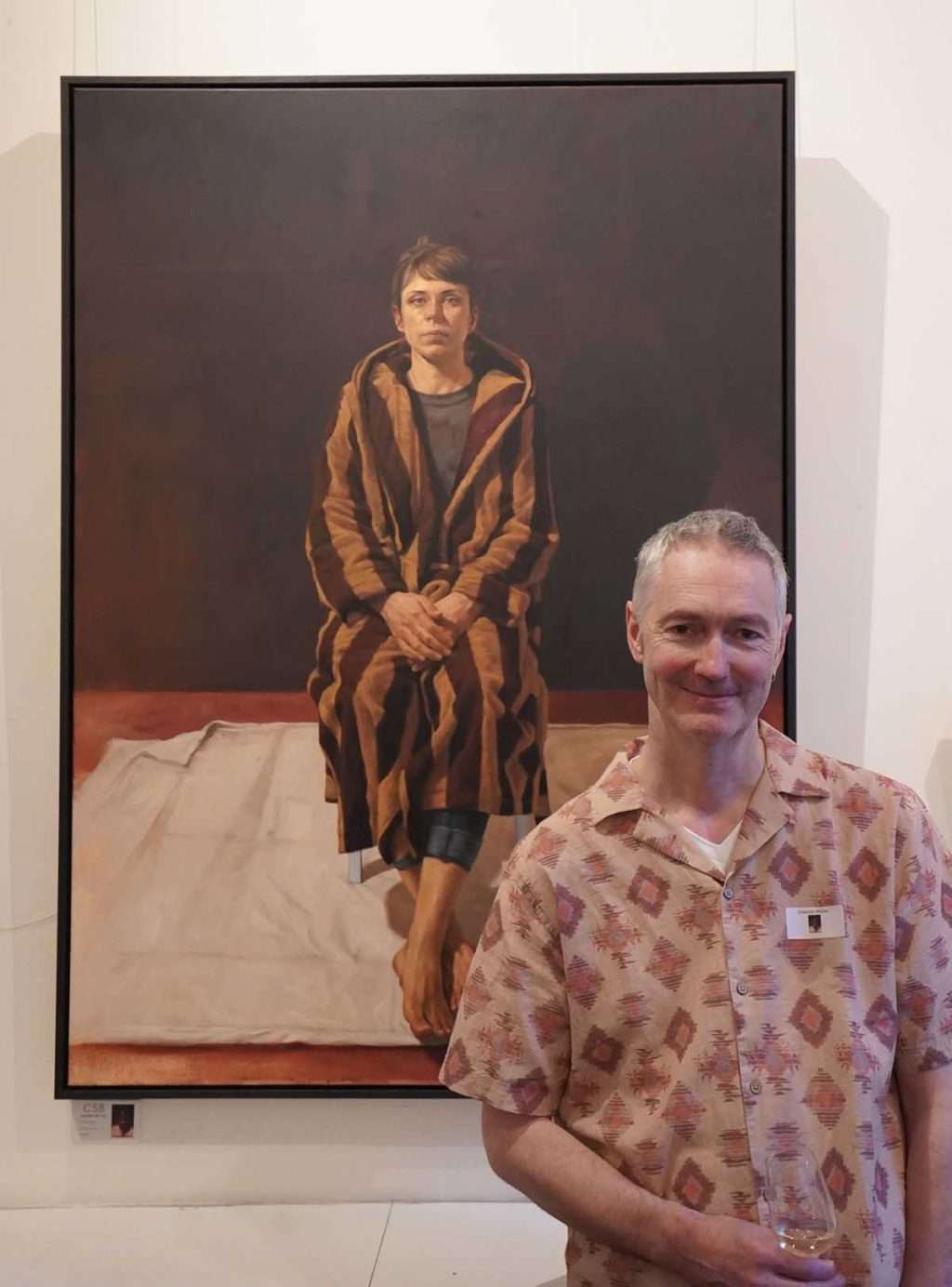 Graeme Wilcox in front of his portrait 'D in Stripes'